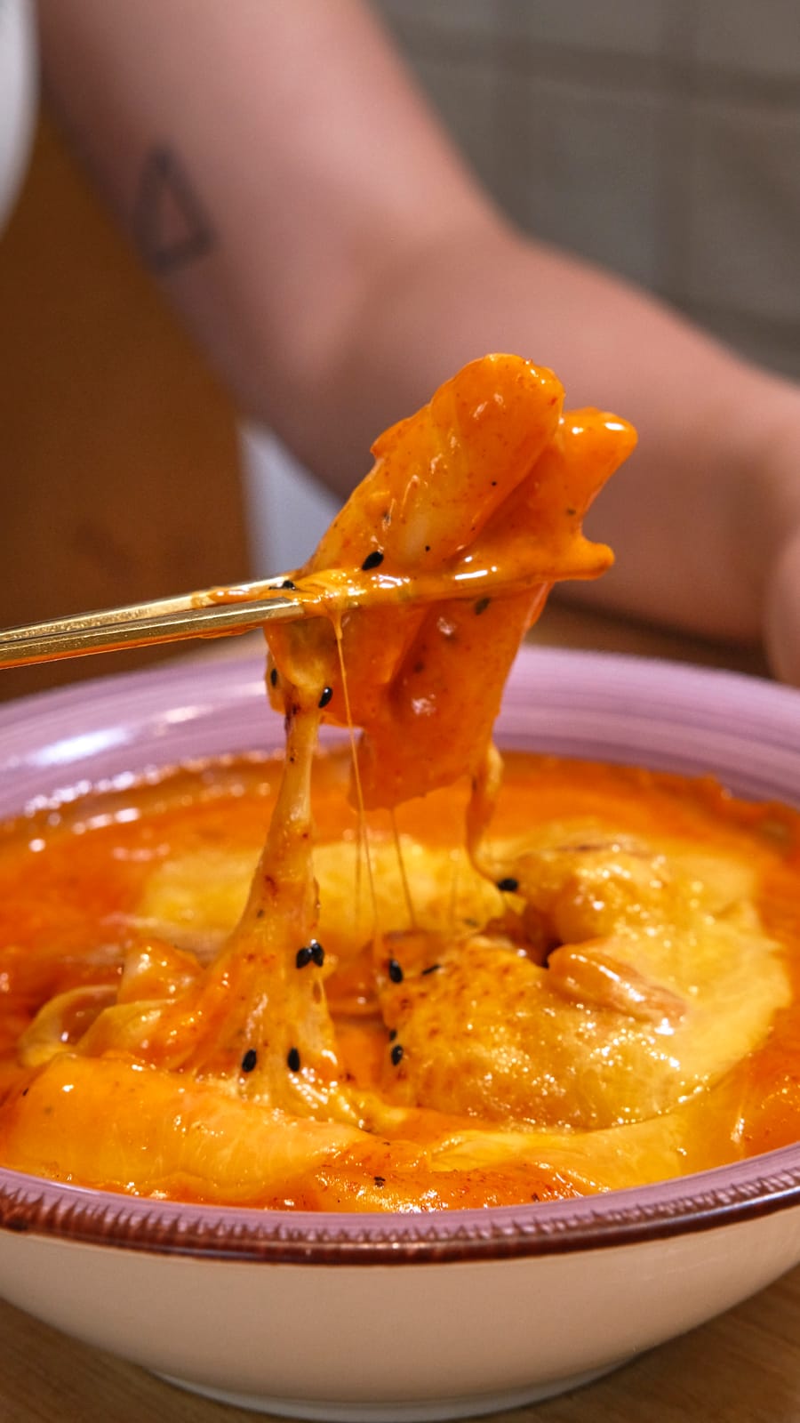 Tteokbokki con queso fundido y sésamo negro